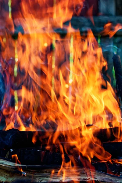 Drewno płonie w kominku. Strona główna Ciepłe ognisko pomarańczowe z kawałkami drewna — Zdjęcie stockowe