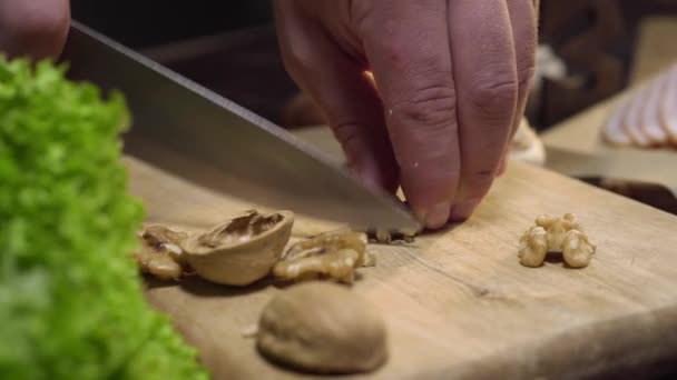 Chef corta nueces en la ensalada de cocina de mesa de madera — Vídeos de Stock