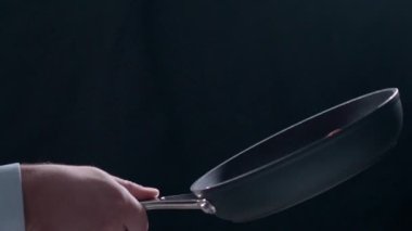 Şef tavaya kızarmış domuz pastırması atıyor.