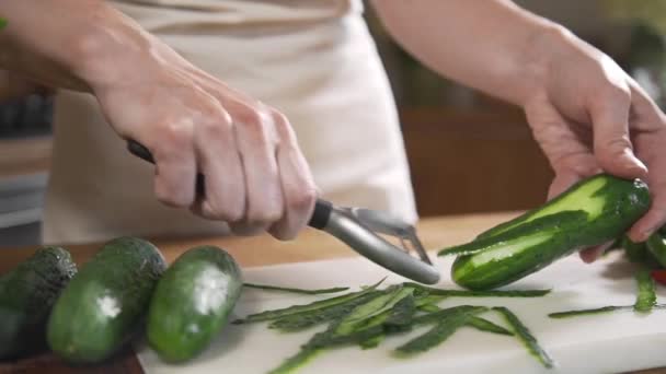 Koch schält Gurken für Gemüsesalat — Stockvideo