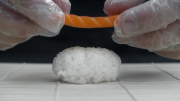 Chef puts salmon slice to the rice making the nigiri in slow motion — Stock Video