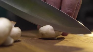 Pişirmek, tahta tahtada çiğ şampiyonları dilimler.
