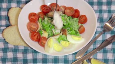 Fırın, sezar salatasına sos ekliyor.