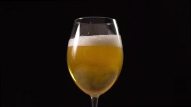 Altın köpüklü bira kadehe yavaşça dökülür.