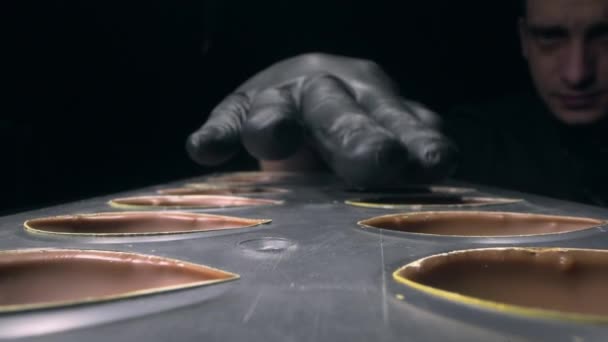 Chocolatier corrigeert en bereidt chocolade mallen voor het vullen met verschillende smaken — Stockvideo