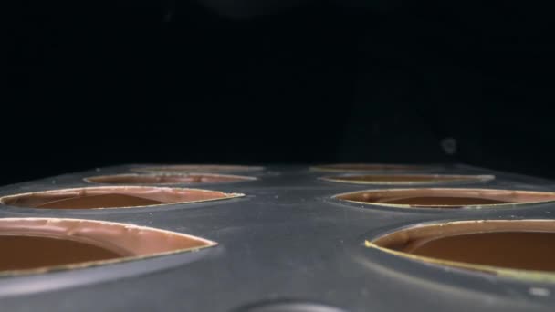 Chocolatier vult chocolade mallen met vloeibare chocolade vulling voor praline — Stockvideo