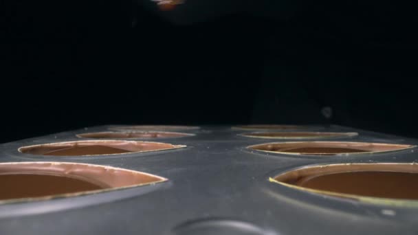 Chocolatier enche moldes de chocolate com recheio de chocolate líquido para praline — Vídeo de Stock