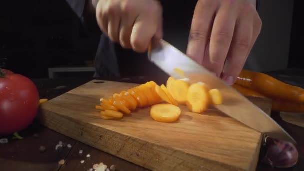 Corte de cenoura crua na tábua de madeira corte de legumes — Vídeo de Stock