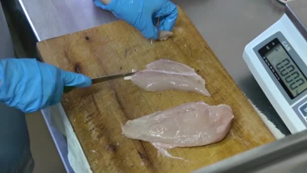 Повар режет грудку сырой курицы — стоковое видео