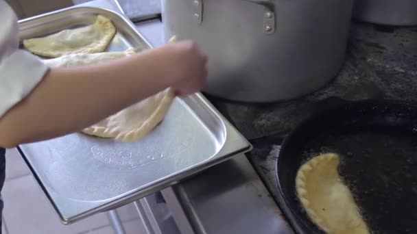 요리하는 사람이 끓는 기름에 고기와 함께 납작 한 티를 낸다 — 비디오