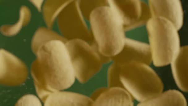 Spadające chrupiące złote chipsy ziemniaczane w zwolnionym tempie — Wideo stockowe