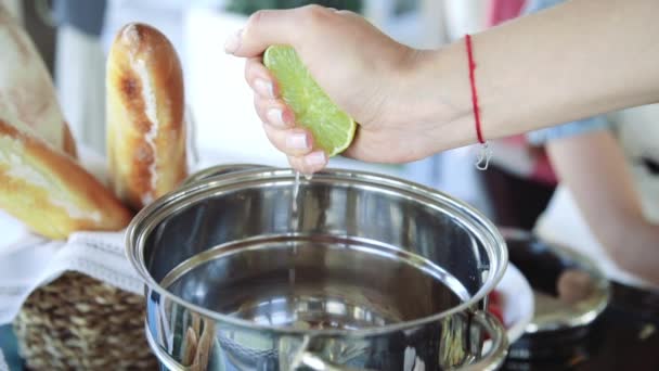 Θηλυκό σεφ συμπιέζει το χυμό λάιμ στο τηγάνι — Αρχείο Βίντεο