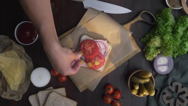 Şefin düz yatağı sandviçe dilimlenmiş domates ekliyor. — Stok video