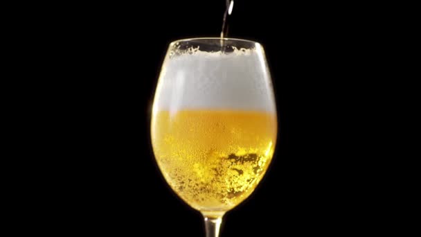 Złote piankowe piwo wlewa się powoli do szklanki — Wideo stockowe