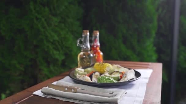 Gegrilltes Gemüse mit Fisch und Pesto-Sauce wird auf dem Tisch serviert — Stockvideo