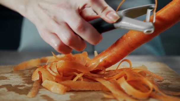 Dona de casa descasca cenoura para salada de legumes — Vídeo de Stock