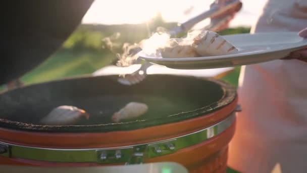 Hemmafru tar varma kalamarier från grillen och lägger dem på tallriken — Stockvideo