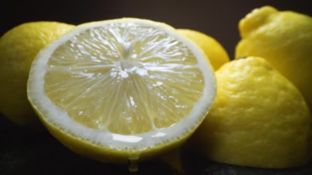 Gota de suco cai da metade cortada de limão maduro — Vídeo de Stock