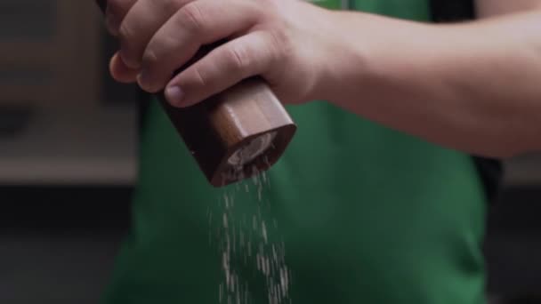 Makro shot szef kuchni używa młyna soli, aby dodać trochę soli do posiłku — Wideo stockowe