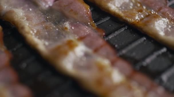 Pedaços de bacon sendo torrado na panela de grelha quente — Vídeo de Stock