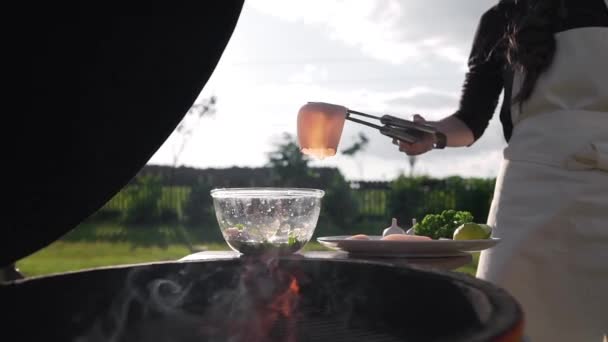 Dává syrové kalamáry do vlastní vařené omáčky před pražením na otevřeném ohni — Stock video