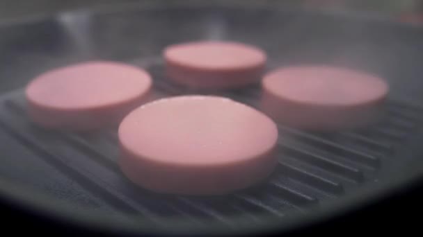 Кольца вкусной колбасы жарятся на сковородке — стоковое видео
