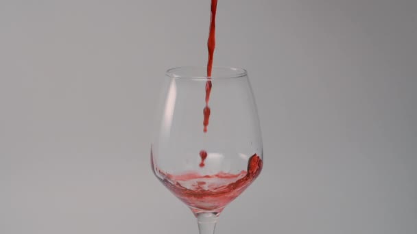 Czerwone wino wlewa się do szklanki w zwolnionym tempie — Wideo stockowe