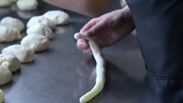 Panadero rueda la masa y envolver una salchicha en — Vídeo de stock