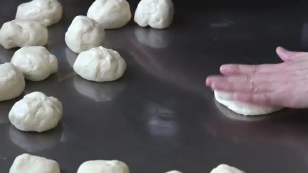 Bäcker rollt den portionierten Teig mit Nudelholz aus — Stockvideo
