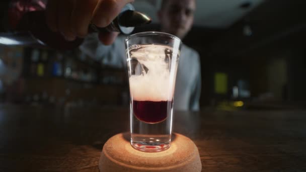 Barmann fügt dem bunten Cocktail in Zeitlupe einen Schluck hinzu — Stockvideo