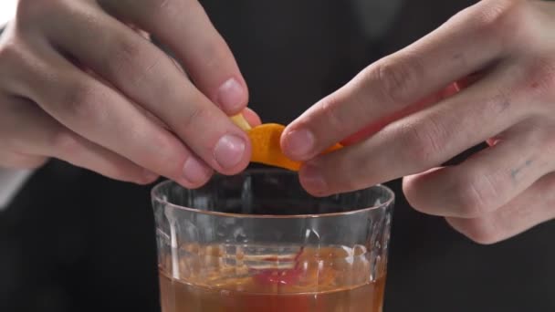 Barmen bardaki alkol içeceğine portakal kabuğu ekliyor. — Stok video