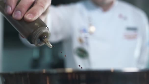 Шеф-повар добавляет оливковое масло в приготовление блюда в замедленной съемке — стоковое видео