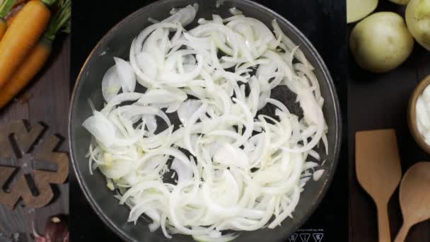 Chef añade aceite de oliva a la sartén caliente y revuelve la cebolla picada por la mesa de espátula de cocina de madera — Vídeos de Stock