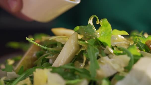 Шеф-кухар додає трохи соусу до салату з зеленню та овочами — стокове відео