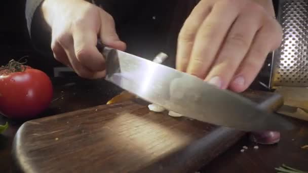 Koch hackt Knoblauch auf dem Holzbrett — Stockvideo