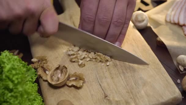 Şef tahta tahtada ceviz keser, salata pişirir. — Stok video
