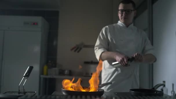 Шеф-повар зажигает пламя на горячей сковороде. — стоковое видео