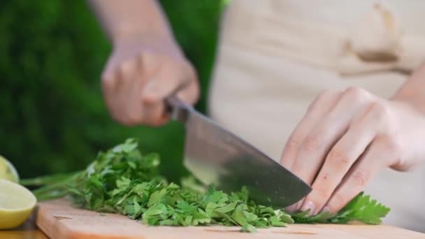 El cocinero corta el perejil en la tabla de madera — Vídeos de Stock