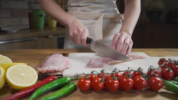O cozinheiro corta o peixe cru antes de cozinhar frutos do mar — Vídeo de Stock