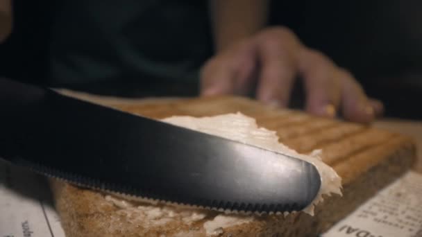 Der Koch streicht Butter mit dem Messer auf knusprig geröstetem Toastbrot und macht das Sandwich — Stockvideo