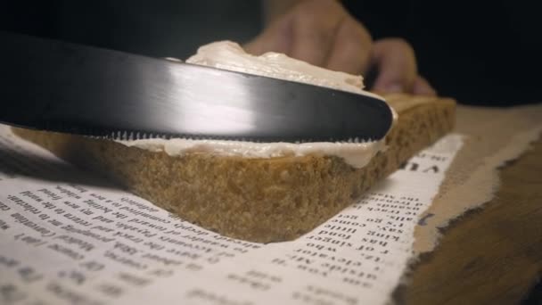 Kucharz rozprowadza masło nożem na chrupiącym pieczonym chlebie tostowym robiąc kanapkę — Wideo stockowe
