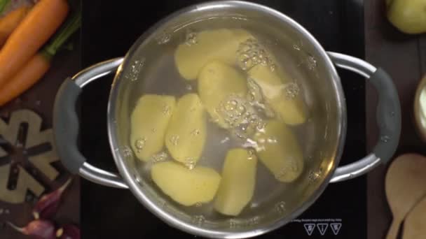 Ρίχνει αποφλοιωμένες πατάτες στο βραστό νερό — Αρχείο Βίντεο