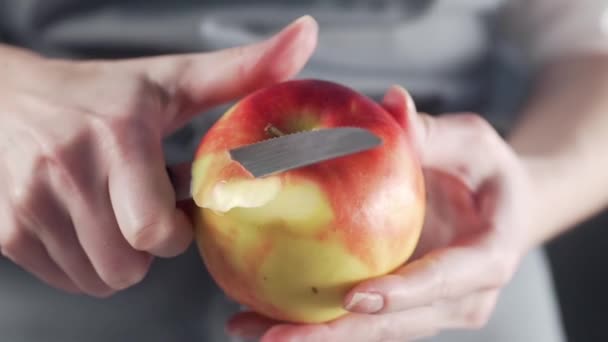 Frau schält roten Apfel für den Obstsalat — Stockvideo