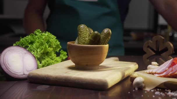 Scivolo zoom colpo chef prende sottaceti dalla ciotola sul tavolo della cucina — Video Stock