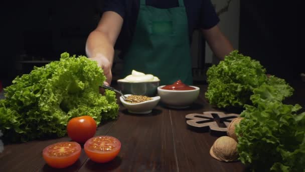 Schieberegler zoomen Schuss Koch kocht Gemüse und nimmt Senf mit Löffel — Stockvideo