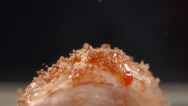 Sushi roll is sprinkled with grinded walnuts in slow motion — Stock Video