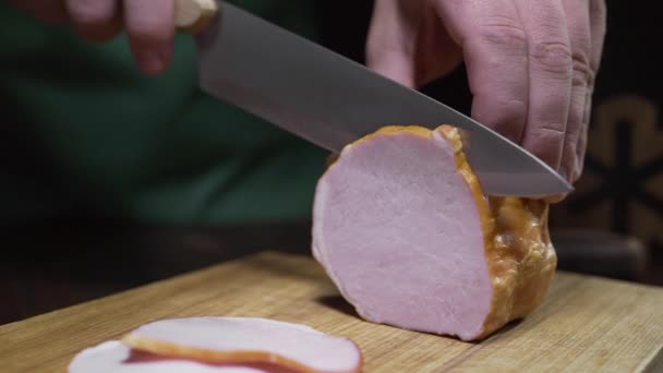 Смачне натуральне шинку нарізають гострим ножем на дерев'яній дошці — стокове відео