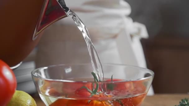 El cocinero blanquea los tomates en el vaso con el agua caliente — Vídeo de stock