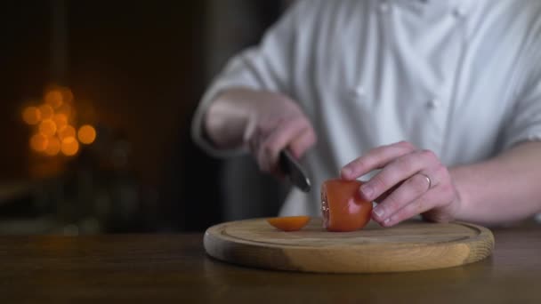 Der Koch schneidet frische rote Tomaten auf das Holzbrett — Stockvideo