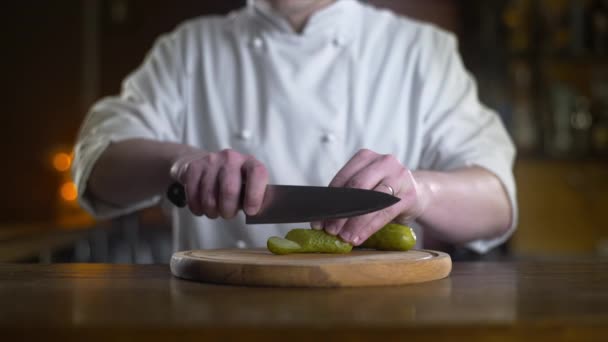 Der Koch schneidet Essiggurke in Zeitlupe auf dem Holzbrett — Stockvideo